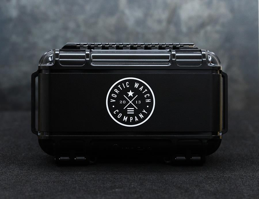 Close up of a watch case, black plastic with white logo.