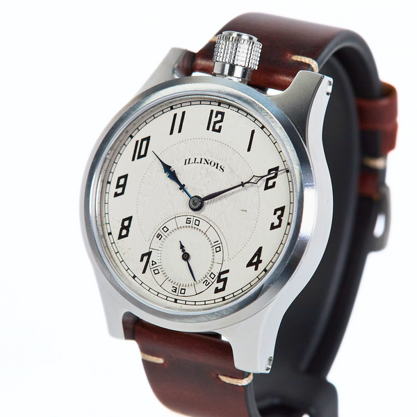 A vintage-style wristwatch with a silver-toned metal case, a white dial featuring black Arabic numerals and hands, and a brown leather strap, shown on a plain white background.