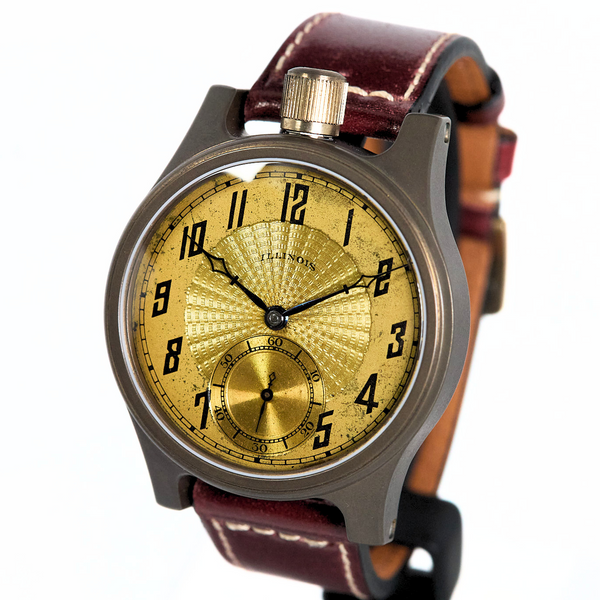 A vintage-style wristwatch with a round gold dial, black Arabic numerals, a gold subdial, and a dark brown leather strap, shown on a plain white background.
