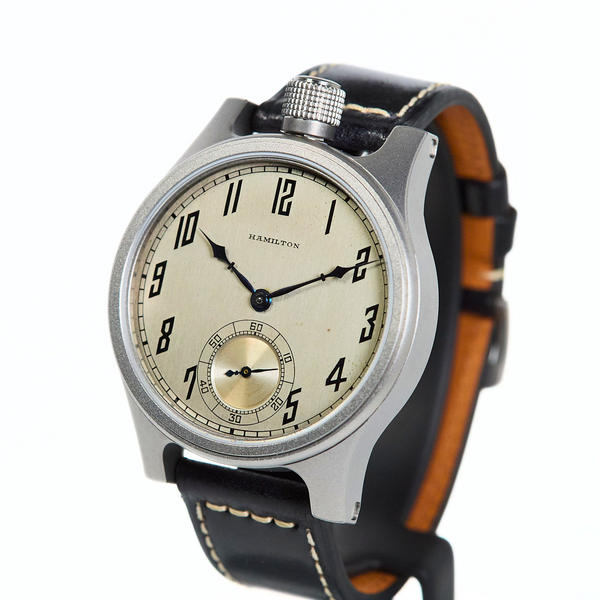 A Hamilton watch with a silver-toned metal case, a cream-colored dial, and a black leather strap with white stitching and a tan interior lining, shown on a plain white background.