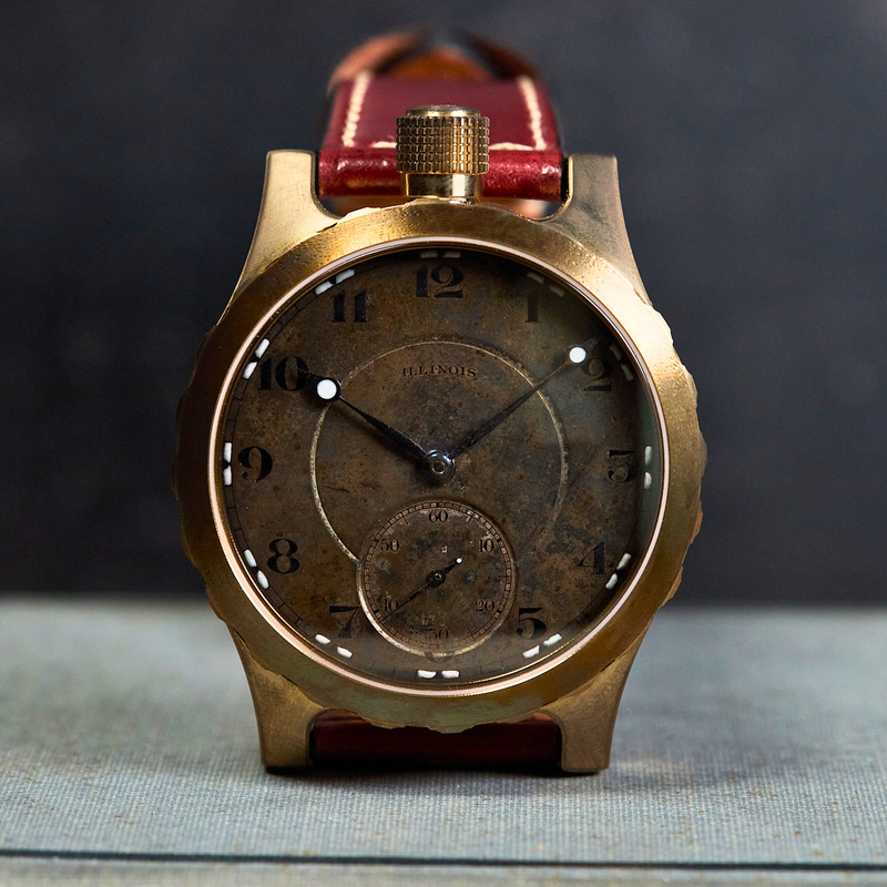 Vintage-style watch with a red strap on a textured surface