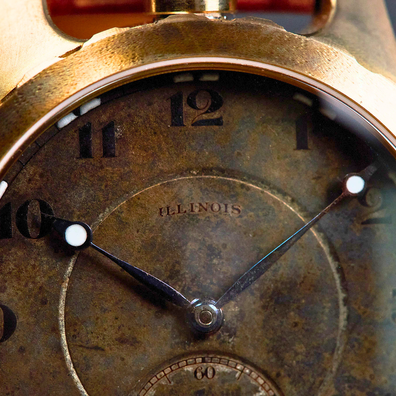 Vintage-style watch with a metallic casing and worn face.