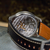 Watch with visible mechanical components on a textured surface