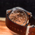 Mechanical watch with brown leather strap on a wooden surface