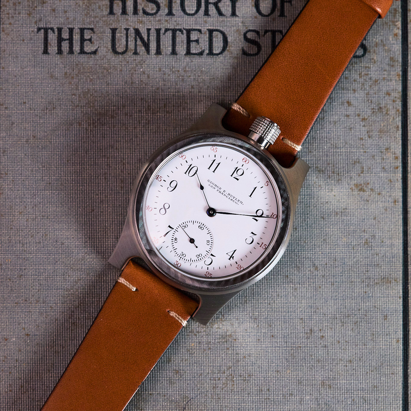 Watch with brown leather strap on a book titled 'History of the United States'