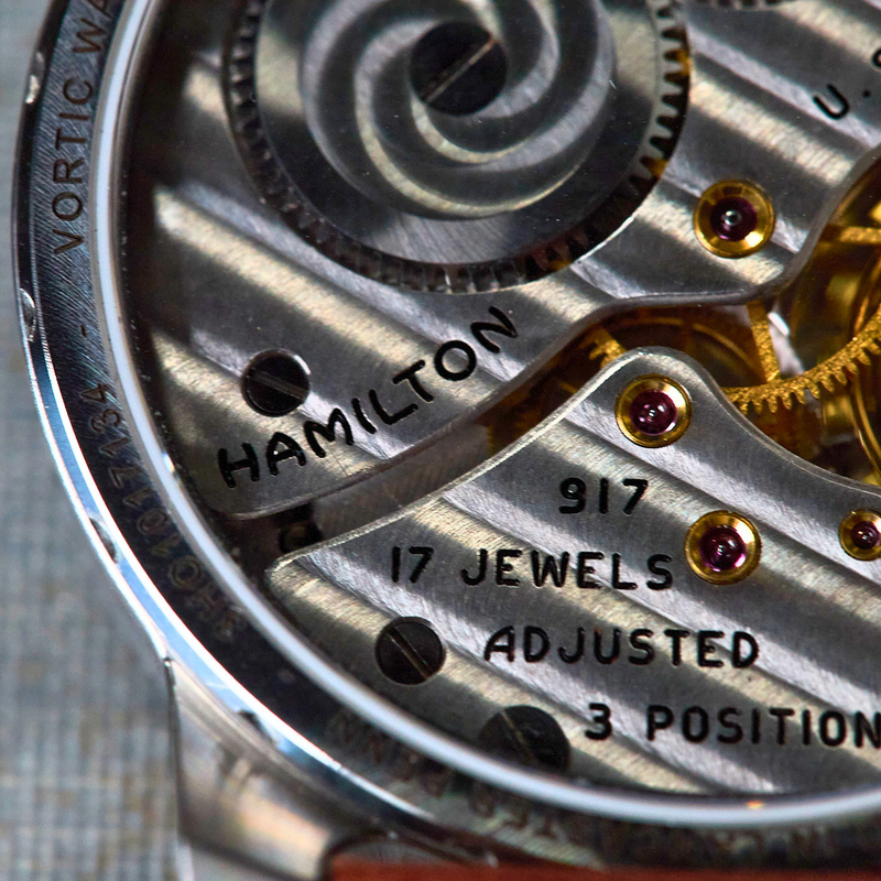 Close-up of a Hamilton watch mechanism with visible branding and specifications.