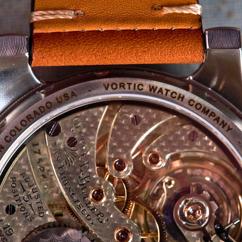 Close-up of a watch with visible mechanical components and 'Vortic Watch Company' branding.