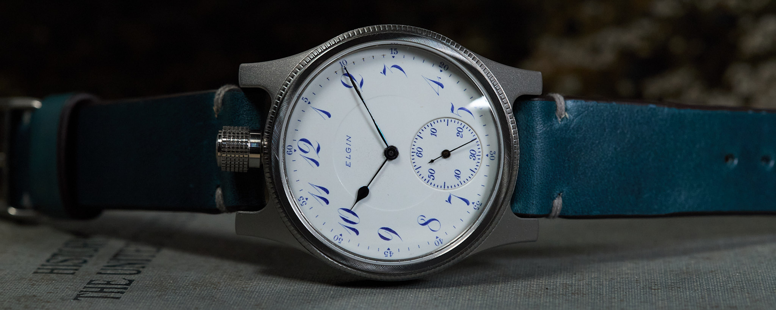 Wristwatch with blue strap on a textured surface